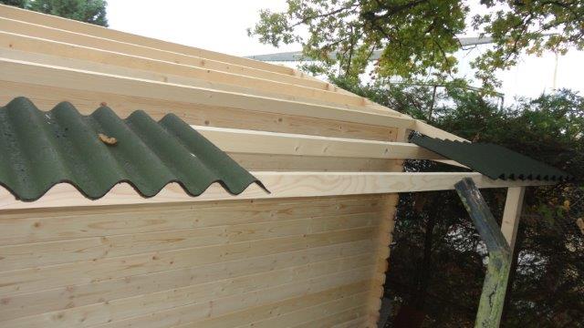 Pose des revêtements de toit d'un abri de jardin en commençant par les côtés